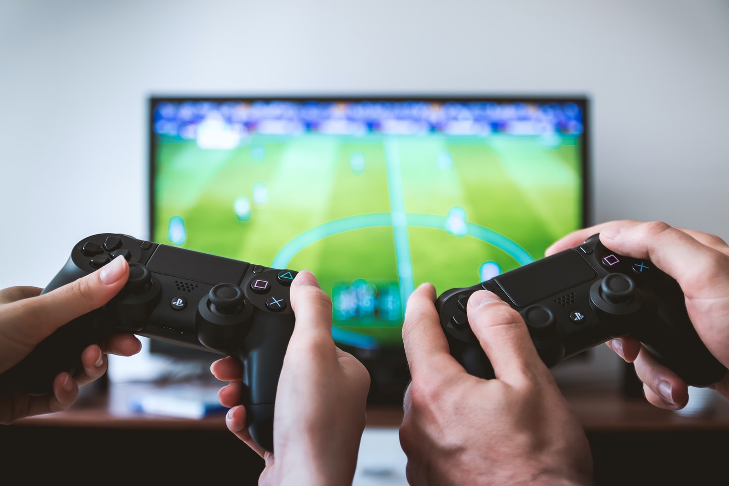 Two people holding gaming controllers in front of a TV screen